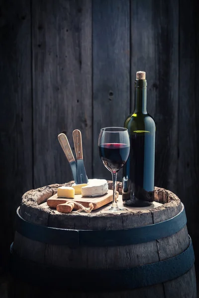Red wine and camembert cheese on oak barrel — Stock Photo, Image