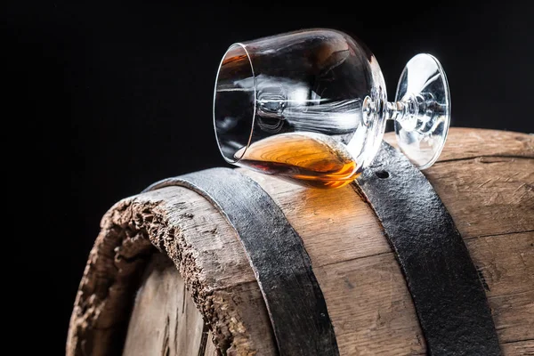 Glass of good cognac on oak barrel — Stock Photo, Image