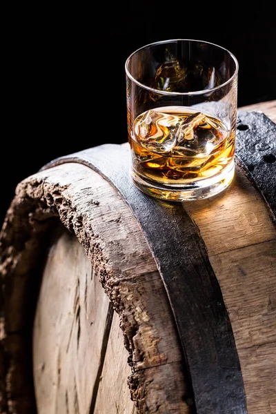 Glass of good whisky with ice in the distillery basement — Stock Photo, Image