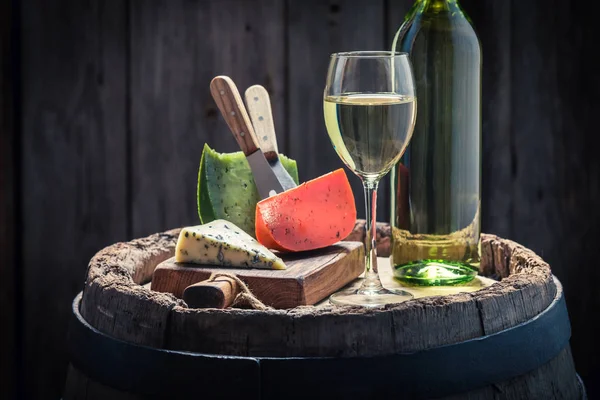 White wine and mix of cheese on oak barrel — Stock Photo, Image