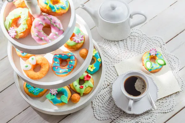 Deliciosas rosquillas servidas con café sobre mesa blanca — Foto de Stock