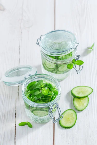 Water with fresh cucumber and mint on white table — Stock Photo, Image