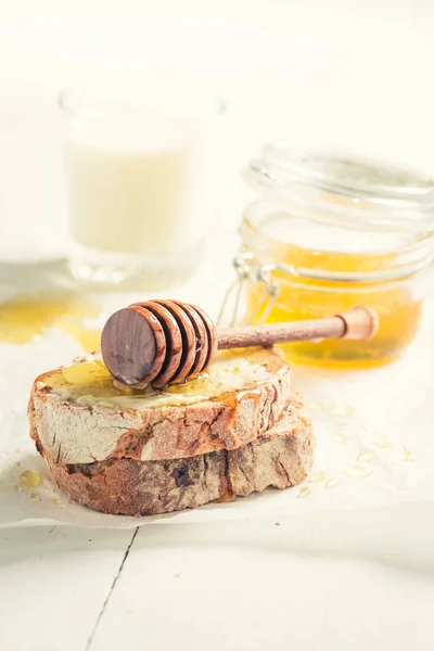 Closeup of sandwich with honey and milk — Stock Photo, Image