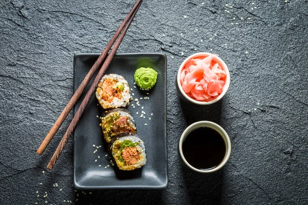 Köstliches Sushi aus Lachs und Avocado auf schwarzem Felsen — Stockfoto