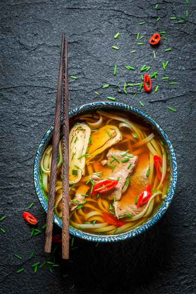 Nikmati sup kari merah Anda dengan sumpit di batu hitam — Stok Foto