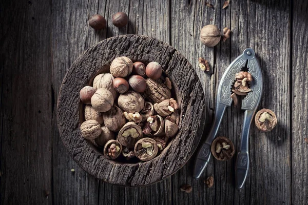 Gustose noci e nocciole con su tavolo rustico in legno — Foto Stock