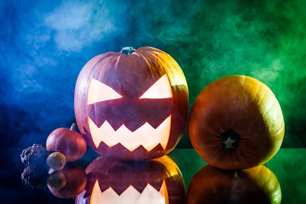 Halloween pompoen hoofd met kleur rook op zwarte achtergrond — Stockfoto