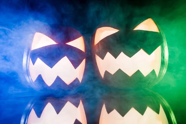 Two glowing pumpkins for Halloween with color lights — Stock Photo, Image