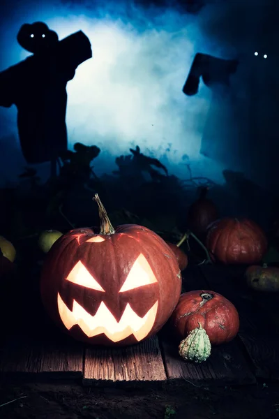 Orangener Halloween-Kürbis mit blauem Nebel und Vogelscheuchen — Stockfoto