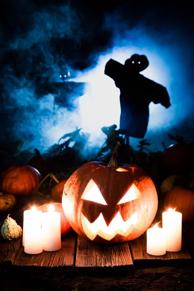 Calabaza espeluznante en el campo oscuro con espantapájaros para Halloween —  Fotos de Stock