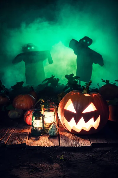 Calabaza naranja de Halloween en el campo oscuro con espantapájaros —  Fotos de Stock