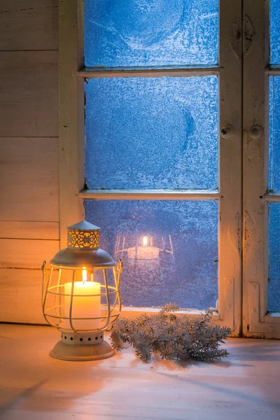 Παγωμένο μπλε παράθυρο και καίγοντας κερί για τα Χριστούγεννα — Φωτογραφία Αρχείου