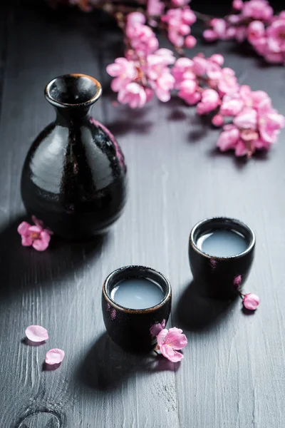 Ongefilterde witte sake sake met bloeiende bloemen — Stockfoto