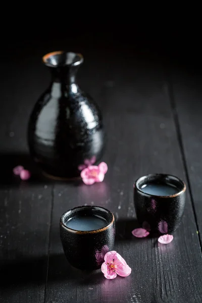 Prêt à boire du saké sur table noire — Photo