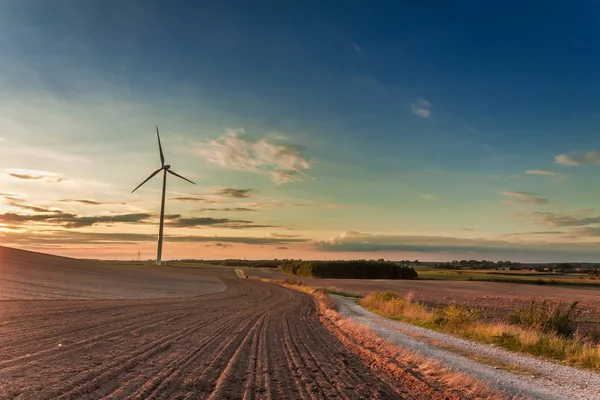 Úžasné soumraku v poli s větrnou turbínu na podzim — Stock fotografie