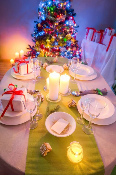Familie kerst tabel instelling met heden en boom in avond — Stockfoto