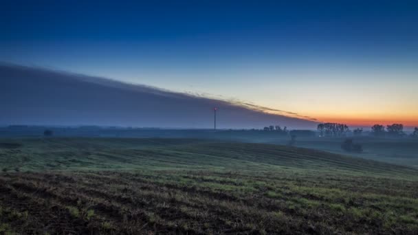 Impresionante amanecer sobre un campo con un molino de viento en otoño, timelapse, 4K — Vídeo de stock