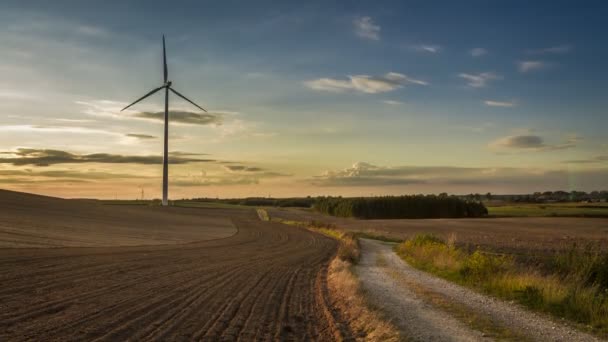 Stunning sunset over a field with a windmill in autumn, timelapse, 4K — Stock Video