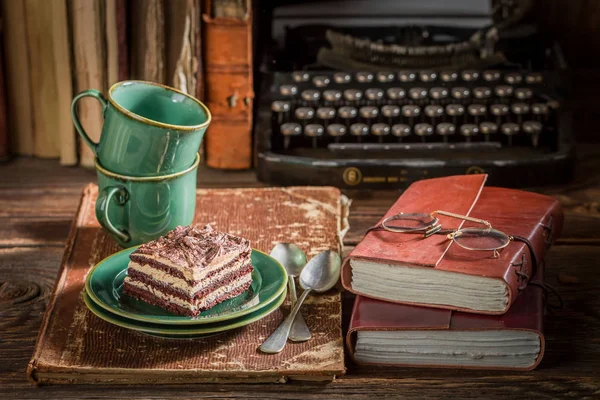 Leckeren Kuchen und Kaffee auf Schreibtisch Schriftsteller — Stockfoto
