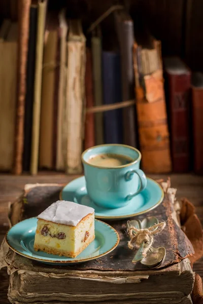 Bolo de queijo doce e café no livro na biblioteca — Fotografia de Stock