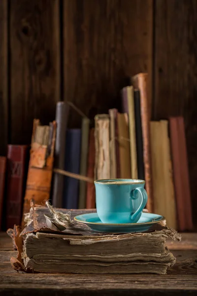 Coffee in blue porcelain on book in library — Stock Photo, Image