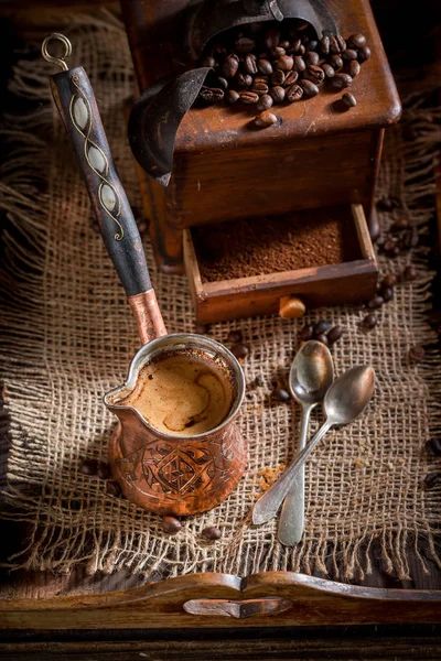 Café recién molido con molinillo viejo y café hervido en olla — Foto de Stock