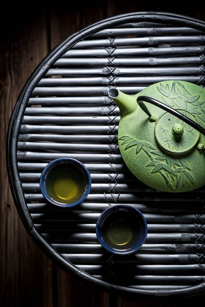 Čerstvý zelený čaj s konvicí na stůl černý bambus — Stock fotografie