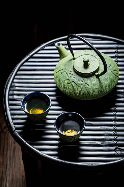 Aproveite o seu chá verde na mesa de bambu preto — Fotografia de Stock