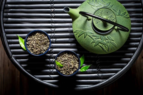 Крупный план чая с чайником на черном бамбуковом столе — стоковое фото