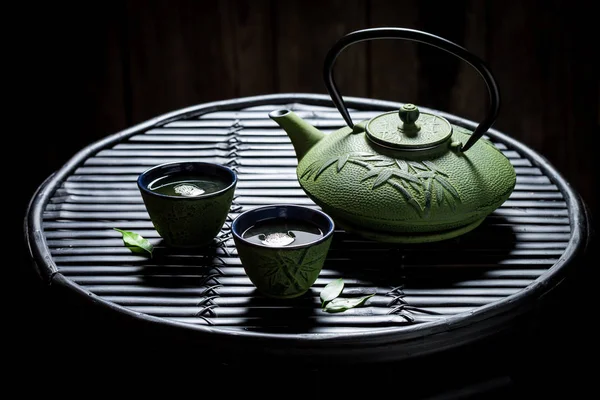 Zöld tea teáskanna és teáscsésze fekete bambusz rock — Stock Fotó