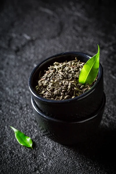 Primer plano del té verde en una taza de té sobre fondo negro —  Fotos de Stock