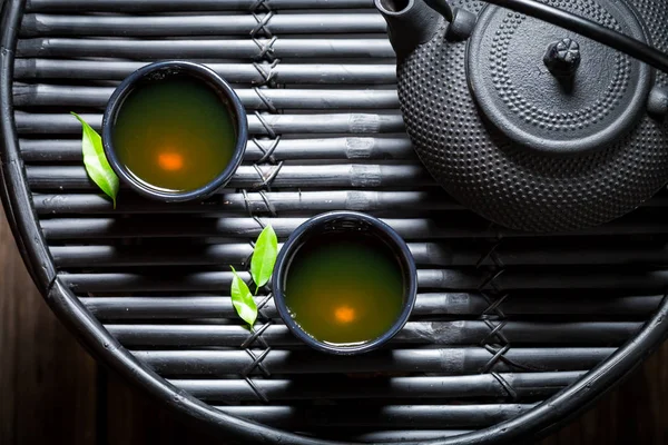 Primer plano del té de hierbas en el restaurante asiático en la mesa negra —  Fotos de Stock