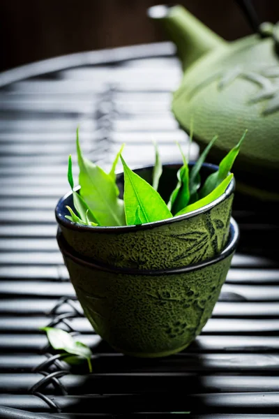 Closeup zeleného čaje s konvicí na černý stůl — Stock fotografie