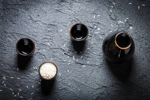 Primer plano del sake en el restaurante asiático en el rock negro —  Fotos de Stock