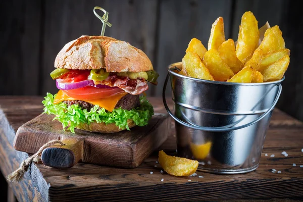 Burger made of vegetables, beef and pepperoni served with chipis — Stock Photo, Image