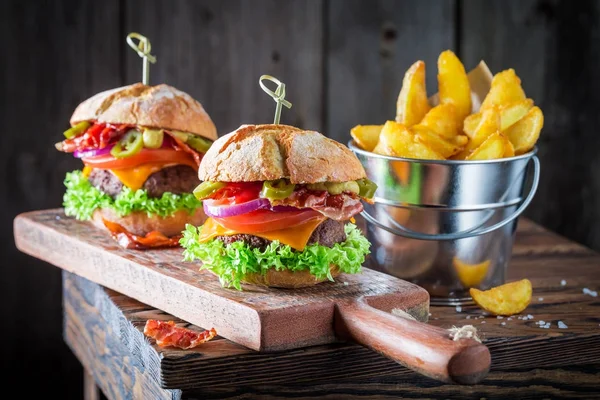 Patatine fritte e hamburger fatti in casa a base di pancetta, pomodoro e manzo — Foto Stock