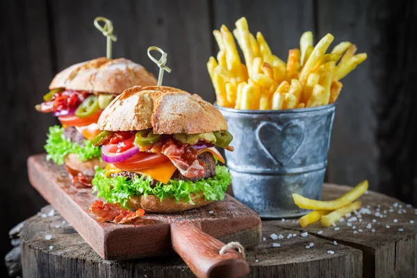 Patatine fritte e hamburger con pancetta, pomodoro e manzo — Foto Stock