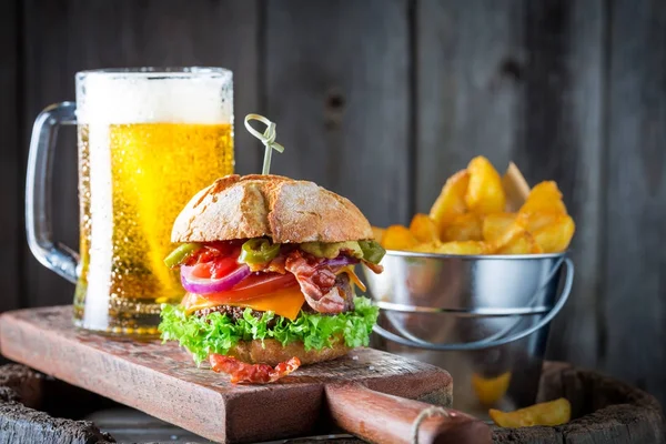 Cerveza fría y hamburguesa a base de carne, queso y verduras — Foto de Stock
