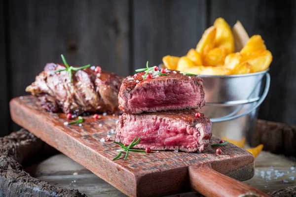 Medium rare steak and chips with rosemary and salt — Stock Photo, Image