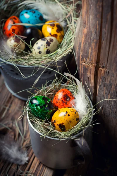 Πολύχρωμα αυγά για το Πάσχα στο σανό σε φόντο ξύλινη — Φωτογραφία Αρχείου