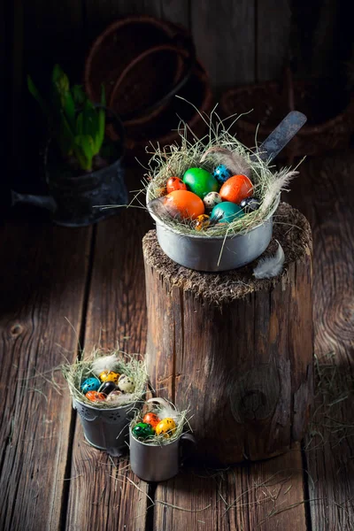 Various Easter eggs with hay and feathers on wooden shack — Stock Photo, Image