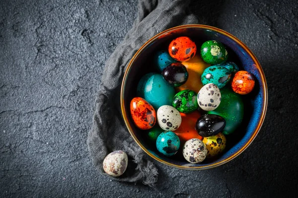 Primer plano de coloridos huevos de Pascua en roca negra —  Fotos de Stock