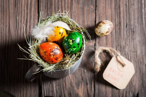 Πολύχρωμα αυγά για το Πάσχα με φτερά στο ξύλινο τραπέζι — Φωτογραφία Αρχείου