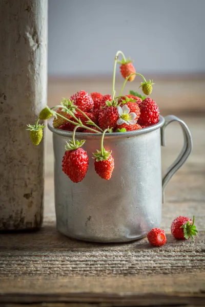 Freshly harvested wild strawberries on old wooden floor — Stock Photo, Image