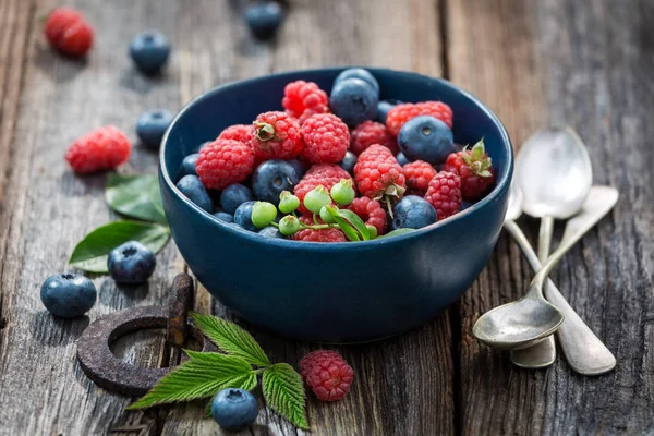 Juicy blueberries and raspberries on old wooden rustic table — Stock Photo, Image