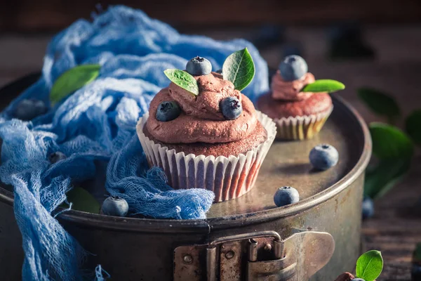 Tasty and brown cupcake with fresh blueberries and cream — Stock Photo, Image