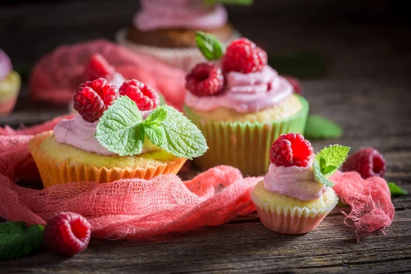 Leckere Cupcake mit frischen Früchten und rosa Sahne — Stockfoto