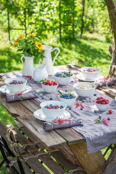 Fresh breakfast with raspberries and blueberries in summer — Stock Photo, Image