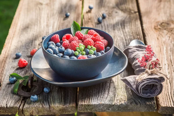 Tasty raspberries and blueberries on old wooden rustic table — Stock Photo, Image