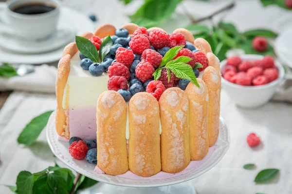 Tasty yoghurt cake with berries and biscuits served with coffee — Stock Photo, Image